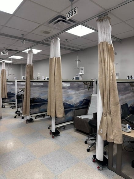 Traditional hospital fabric curtains showing visible contamination and wear — the hygiene problem wall-mounted retractable screens replace